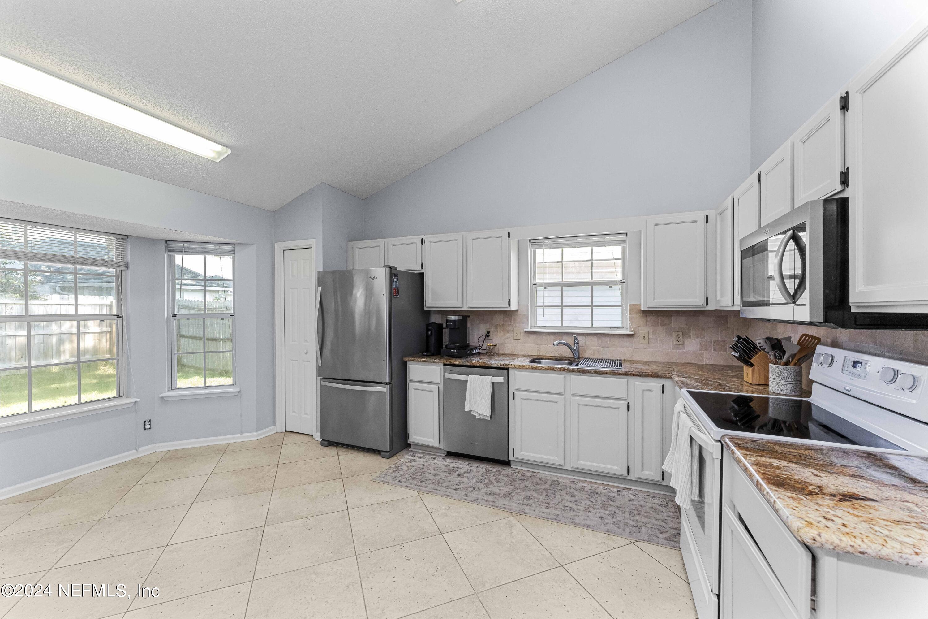 8808 Goodbys Trace Drive Jacksonville, FL 32217 - Photo 8 of 25 a kitchen with a stove a sink dishwasher a refrigerator and cabinets