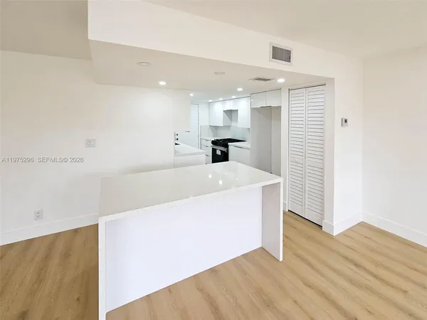 a kitchen with granite countertop a sink and a stove top oven