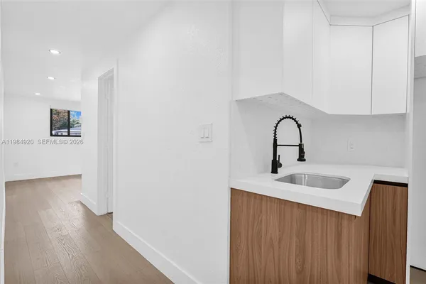a hallway with a wooden floor and cabinets
