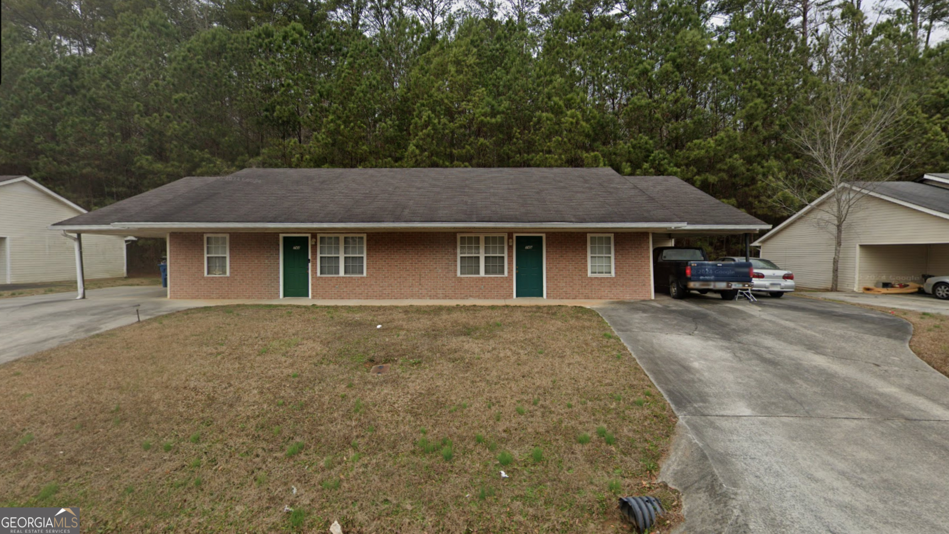 a front view of a house with a garden and tree