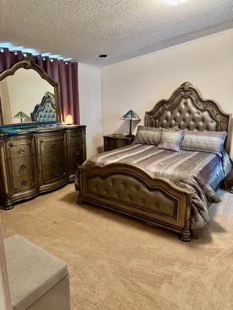 a bedroom with a bed and a painting on the wall