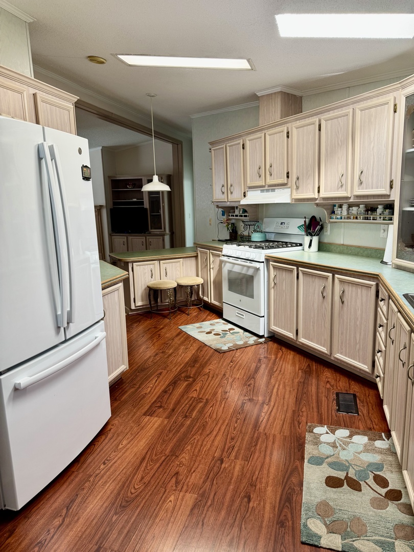 265 Tulip Circle Matteson, IL 60443 - Photo 6 of 25 a kitchen with granite countertop a refrigerator a stove top oven and white cabinets