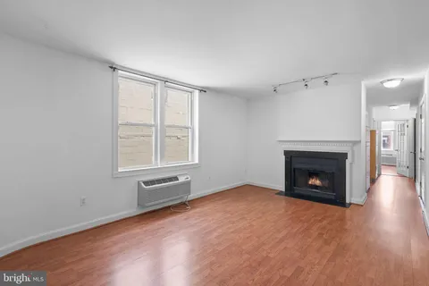 wooden floor fireplace and windows in an empty room