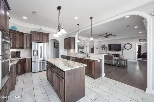 a kitchen with stainless steel appliances granite countertop a stove a sink and a refrigerator