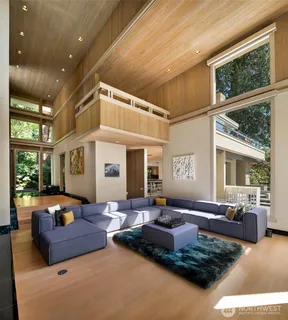 a living room with furniture fireplace and large windows