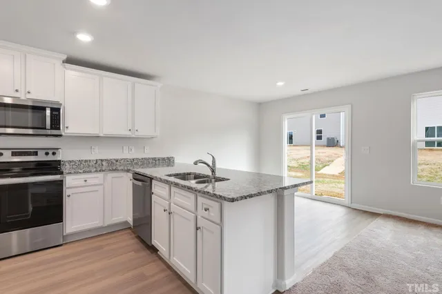 a kitchen with stainless steel appliances granite countertop a sink stove and cabinets