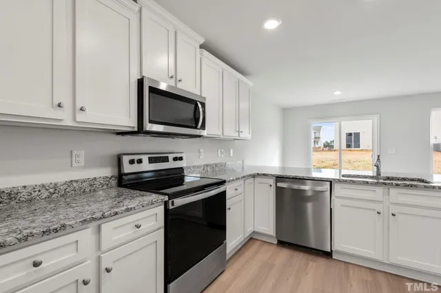a kitchen with granite countertop cabinets stainless steel appliances and a sink