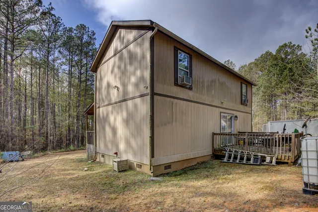 a backyard of a house with barbeque oven and trees