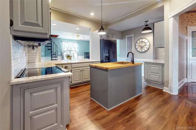 a kitchen with granite countertop a sink a stove and cabinets