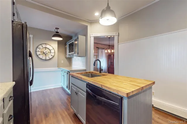 a kitchen with a wooden floor and a clock on wall