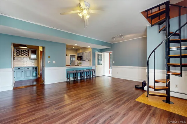 a view of a livingroom with furniture wooden floor and staircase