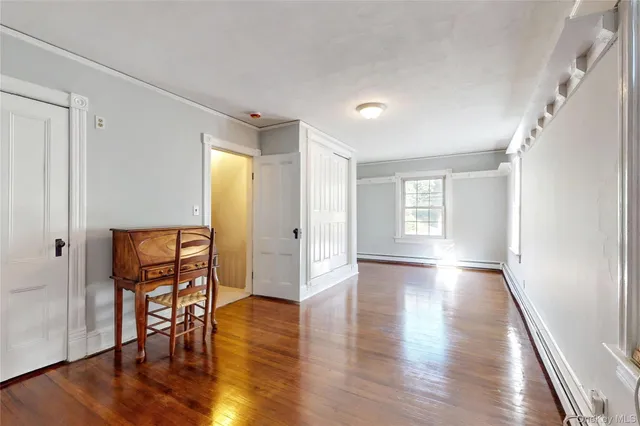 a view of a hallway with wooden floor and windows