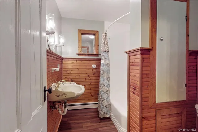 a view of a room with wooden floor and mirror