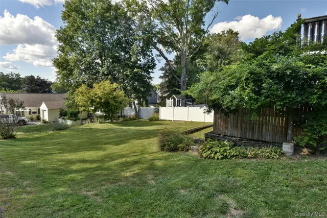 a view of a house with a big yard and large trees