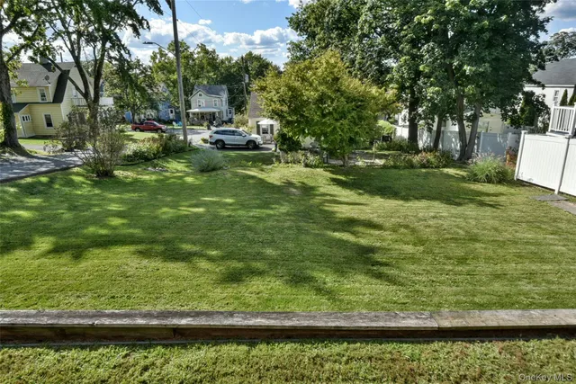 a view of a garden with a bench and trees around