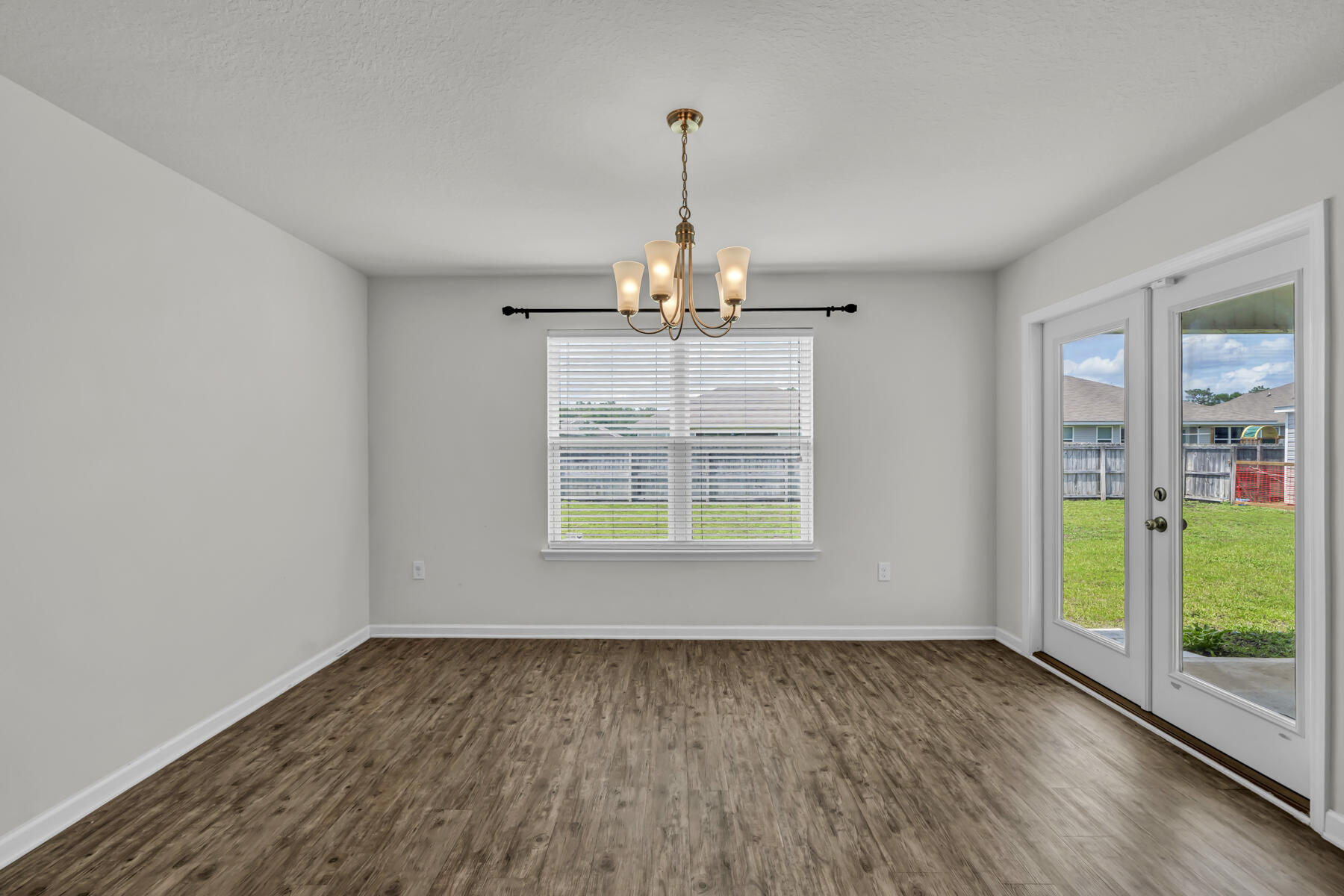 3005 Raven Lane Crestview, FL 32539 - Photo 7 of 24 an empty room with wooden floor and windows