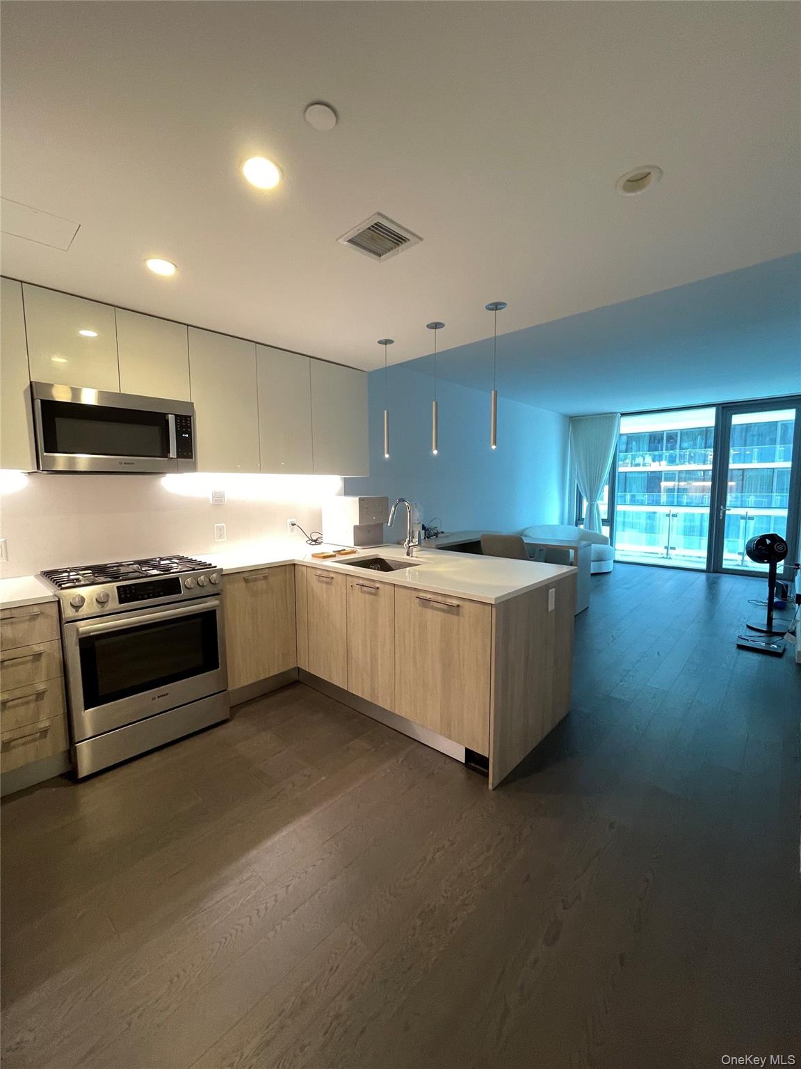 131-05 40 Road, Unit 15M Queens, NY 11354 - Photo 13 of 14 a large kitchen with stainless steel appliances a large counter top a stove and a sink