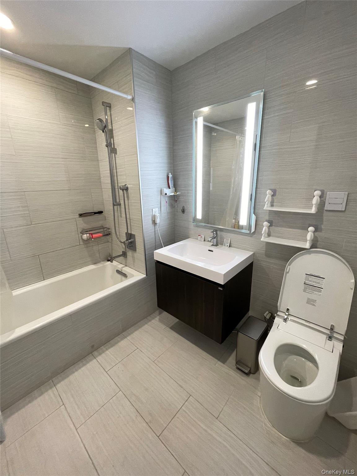 131-05 40 Road, Unit 15M Queens, NY 11354 - Photo 5 of 14 a bathroom with a double vanity sink a toilet and bathtub