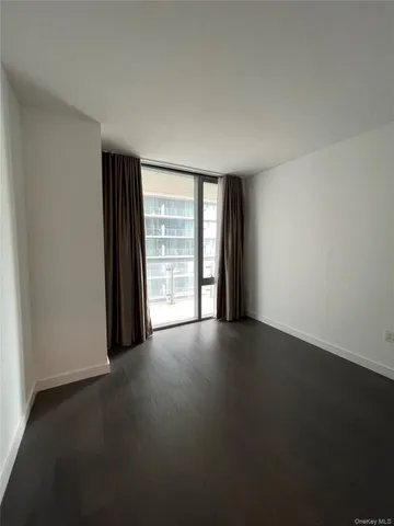 a view of a hallway with wooden floor and a living room
