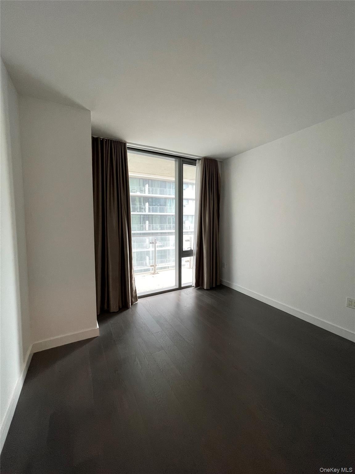 131-05 40 Road, Unit 15M Queens, NY 11354 - Photo 6 of 14 a view of an empty room with a window