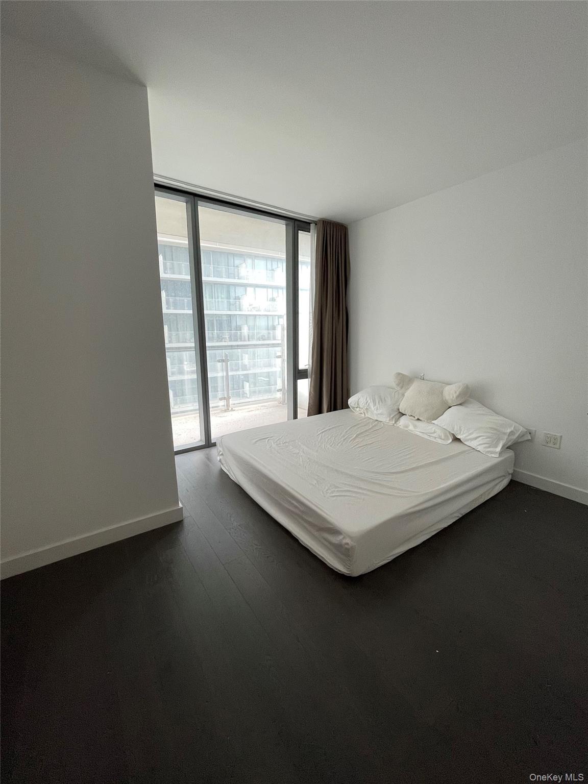 131-05 40 Road, Unit 15M Queens, NY 11354 - Photo 8 of 14 a bedroom with a bed and a large window