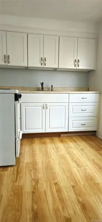 a view of kitchen cabinets and wooden floor
