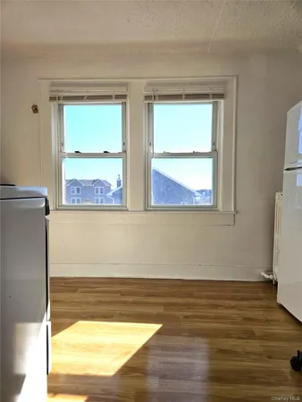a view of a room with wooden floor and a window