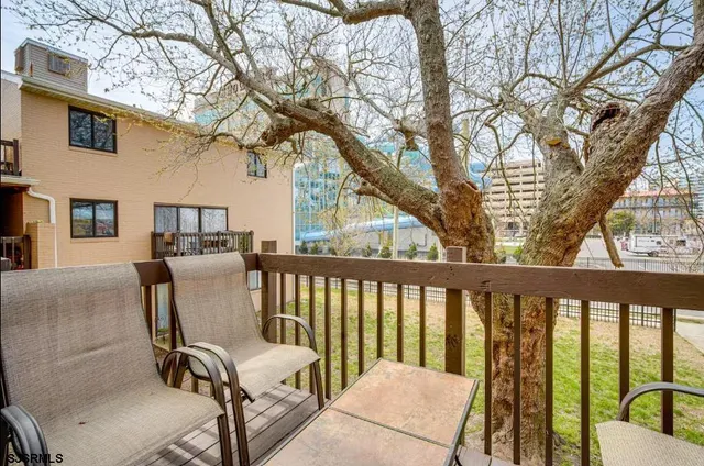 a balcony view with chairs and wooden fence