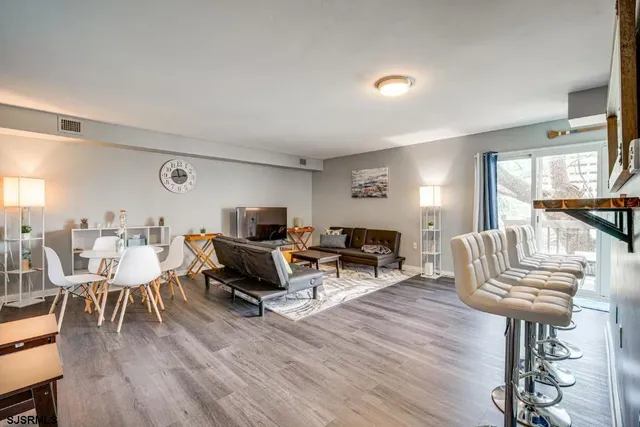 a living room with furniture a wooden floor and a fireplace