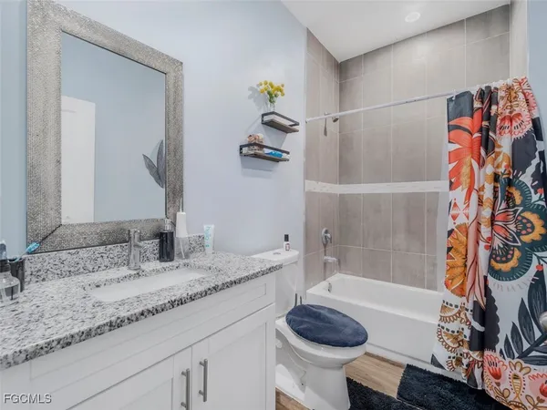 a bathroom with a granite countertop sink and a bathtub
