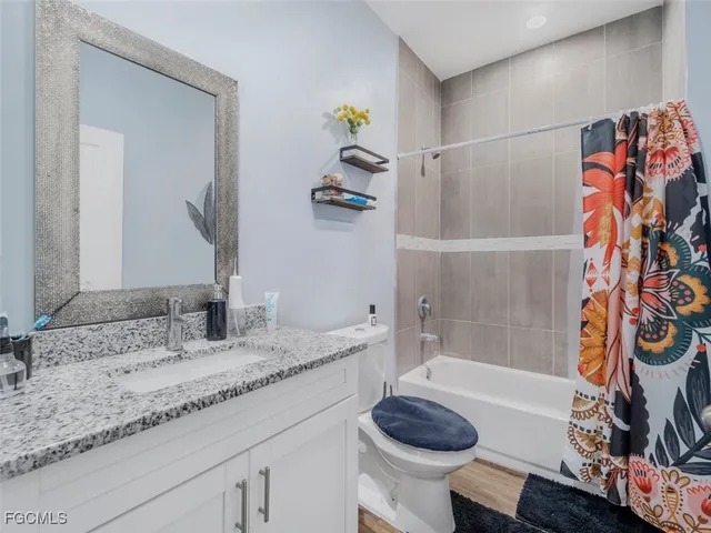 a bathroom with a granite countertop sink and a bathtub