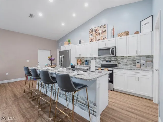 a kitchen with stainless steel appliances kitchen island granite countertop a sink and cabinets