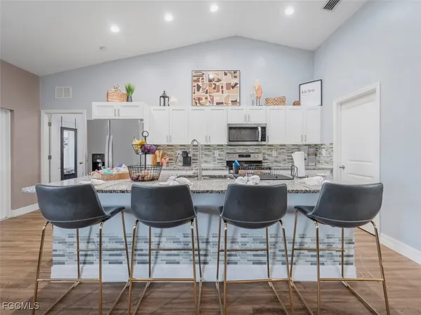 a kitchen with granite countertop a dining table and chairs