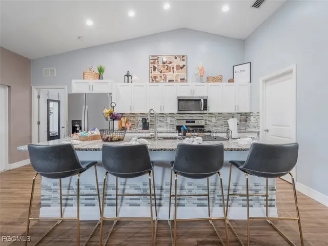 a kitchen with granite countertop a dining table and chairs
