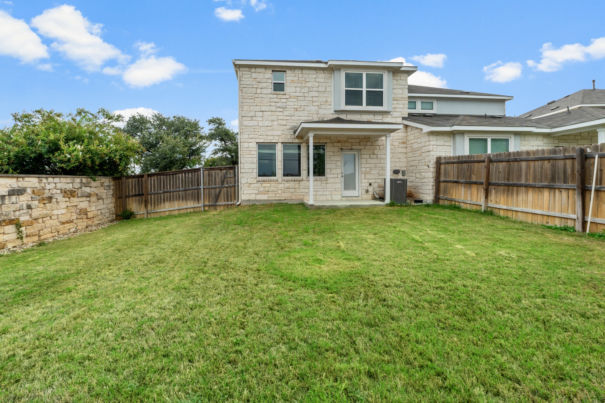 2251 Rocoso Trail Leander, TX 78641 - Photo 31 of 34 A spacious grassy lawn offers plenty of outdoor space beneath a covered back patio.