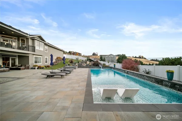 a view of swimming pool with outdoor seating and a garden