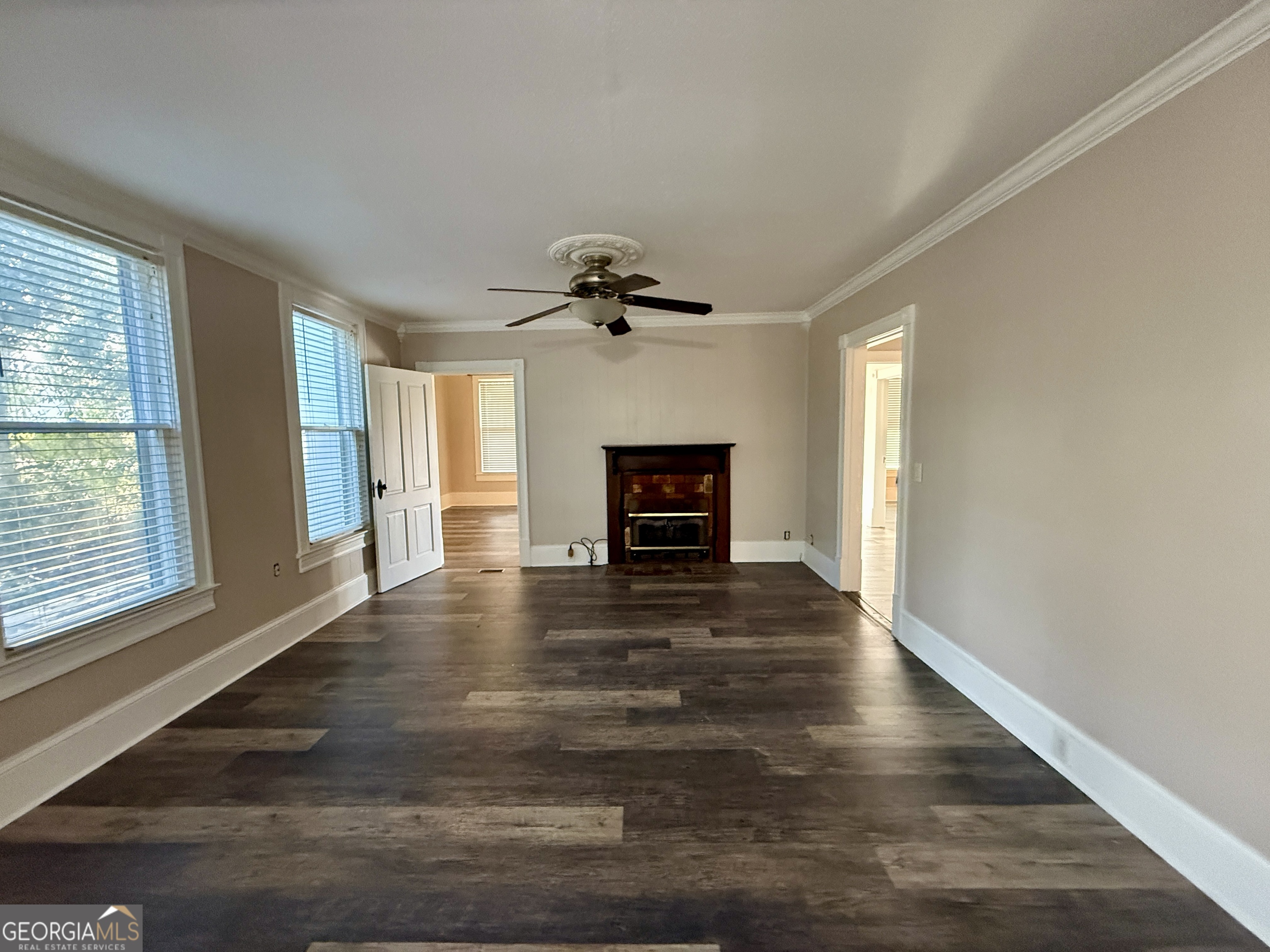 646 McLendon Street Ashburn, GA 31714 - Photo 16 of 63 a view of a livingroom with a fireplace a ceiling fan and wooden floor