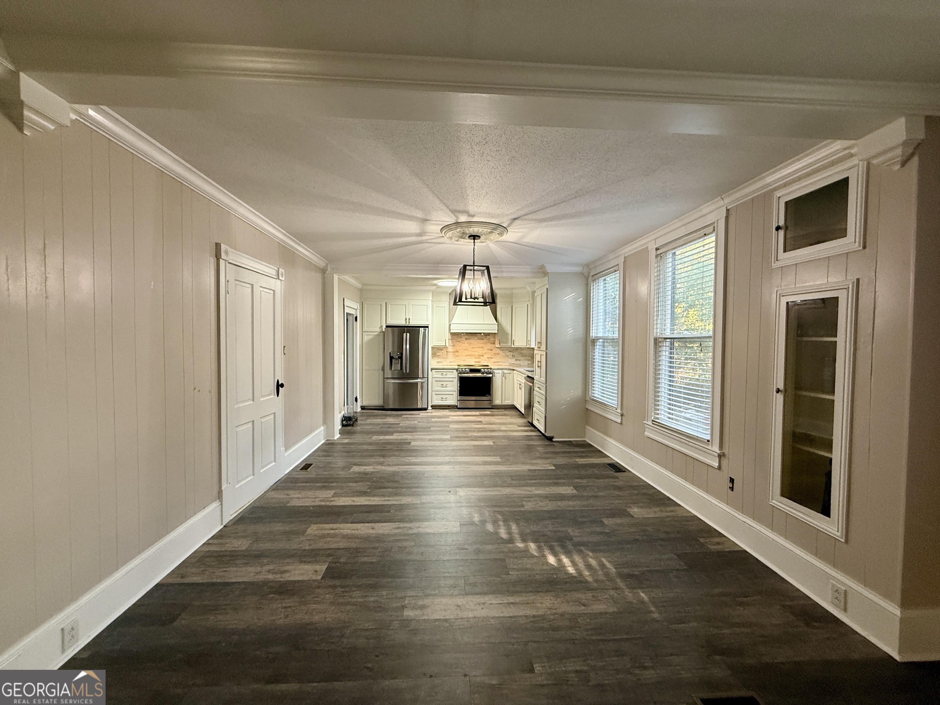 646 McLendon Street Ashburn, GA 31714 - Photo 17 of 63 a view of an empty room with wooden floor a ceiling fan and windows