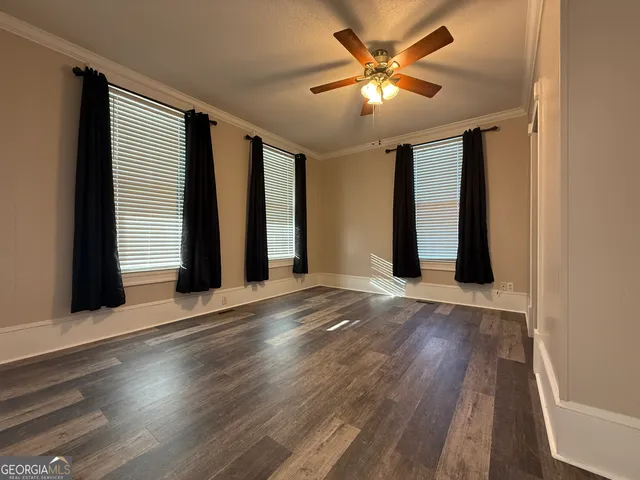 a view of empty room with wooden floor and fireplace