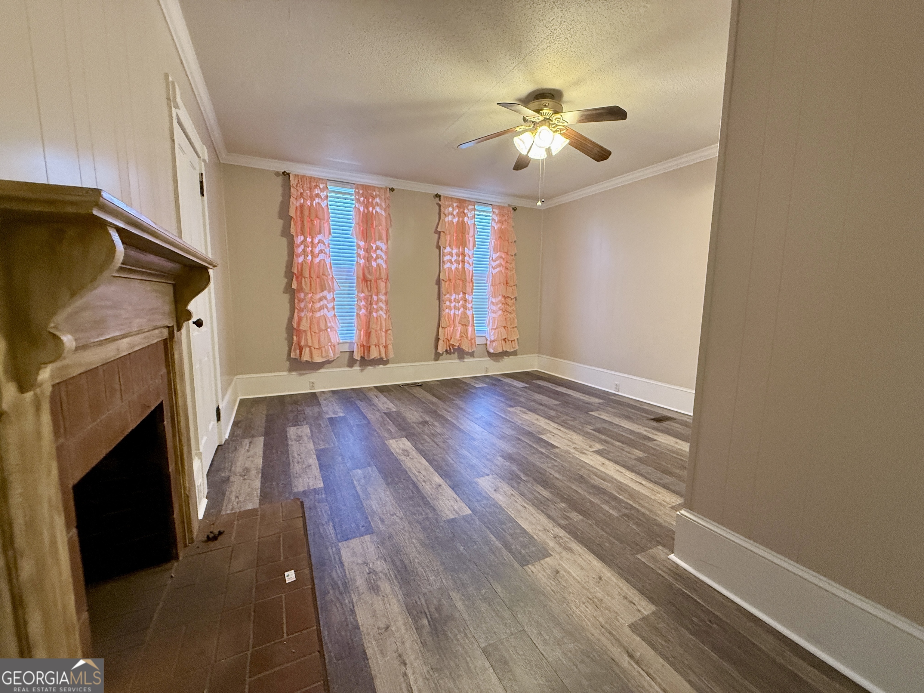 646 McLendon Street Ashburn, GA 31714 - Photo 36 of 63 a view of an empty room with wooden floor fireplace and a window