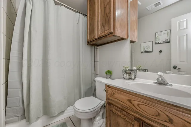 a bathroom with a granite countertop sink and a toilet