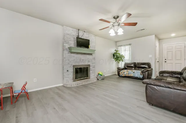 a living room with furniture a fireplace and a flat screen tv