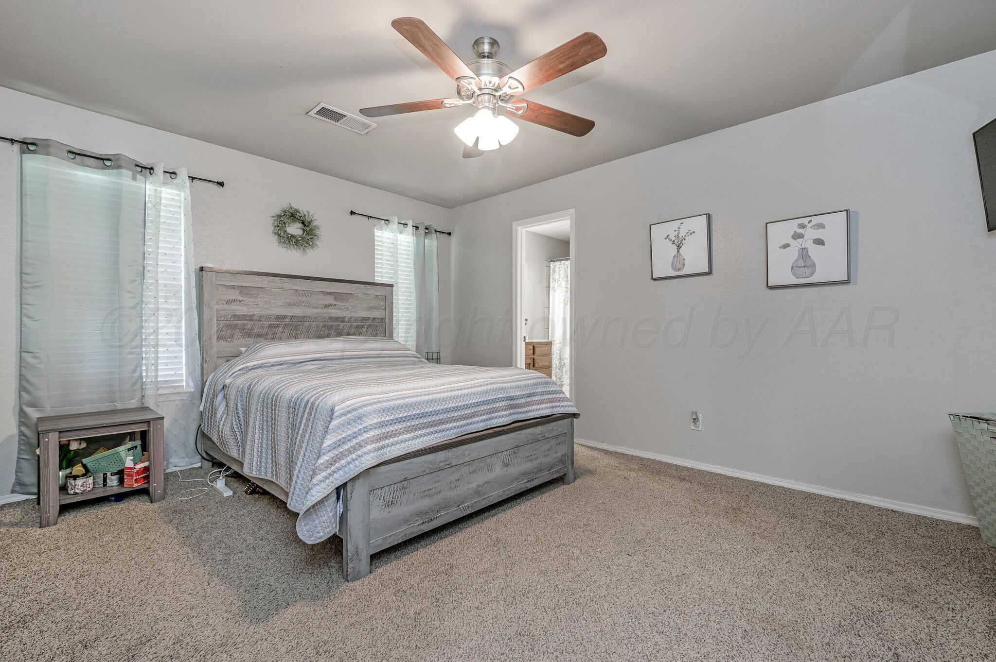 2002 Southwest 61st Avenue Amarillo, TX 79118 - Photo 10 of 21 a bedroom with a bed and a ceiling fan