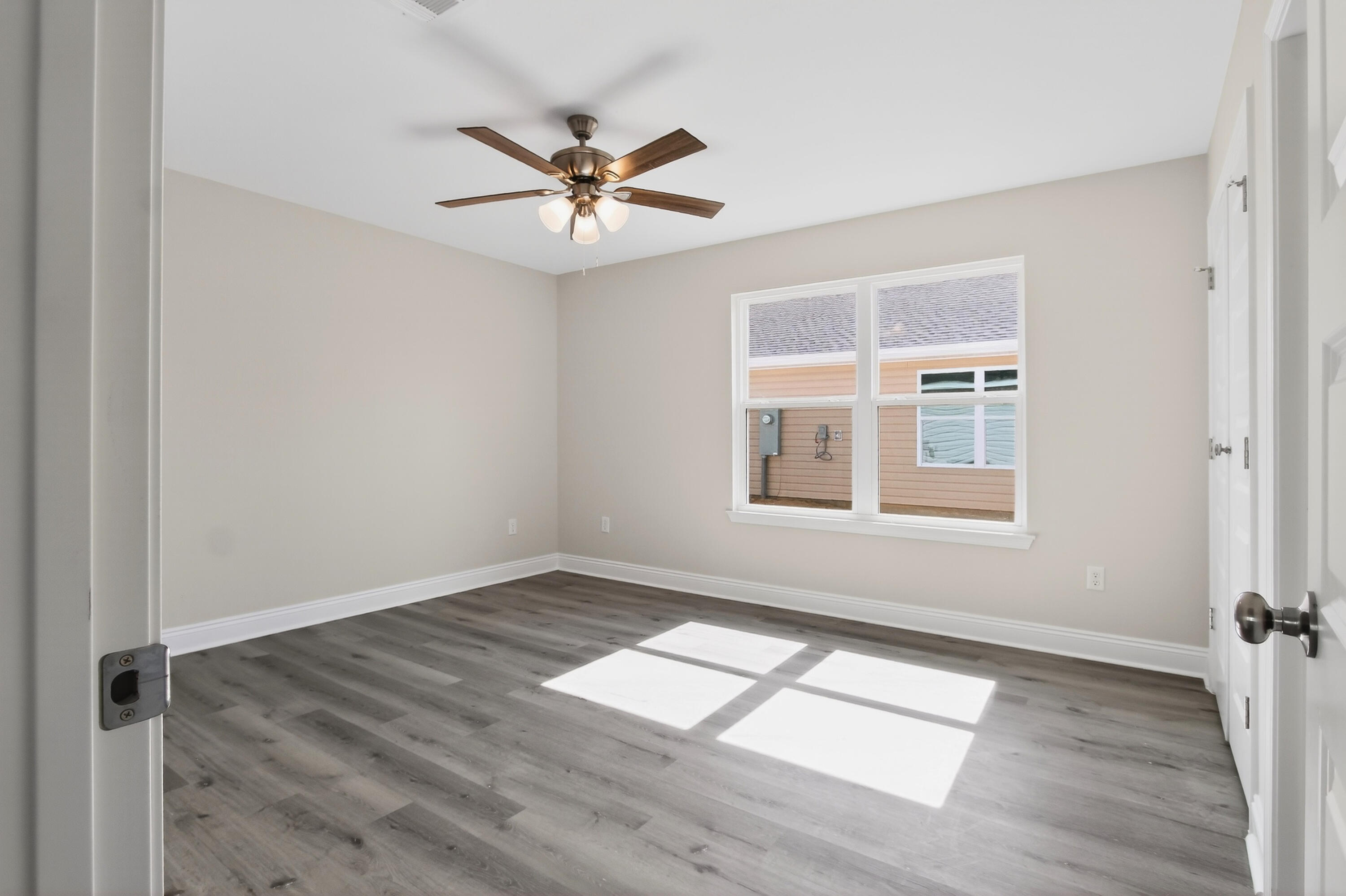 5358 Highview Drive Crestview, FL 32539 - Photo 17 of 31 an empty room with wooden floor fan and windows