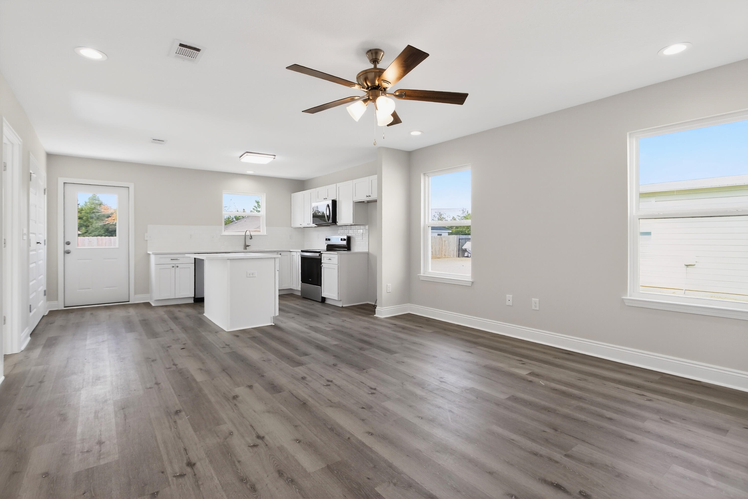 5358 Highview Drive Crestview, FL 32539 - Photo 4 of 31 a view of a livingroom with wooden floor and a ceiling fan