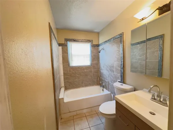 a bathroom with a tub sink mirror and toilet