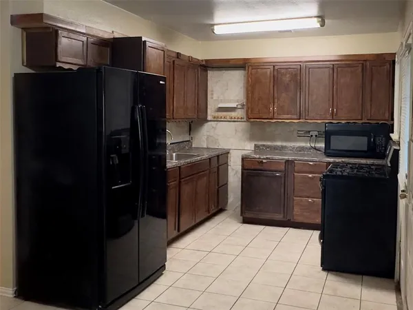 a kitchen with a refrigerator sink and cabinets