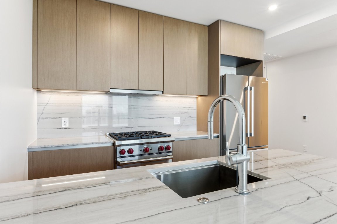 a kitchen with granite countertop a refrigerator and a stove