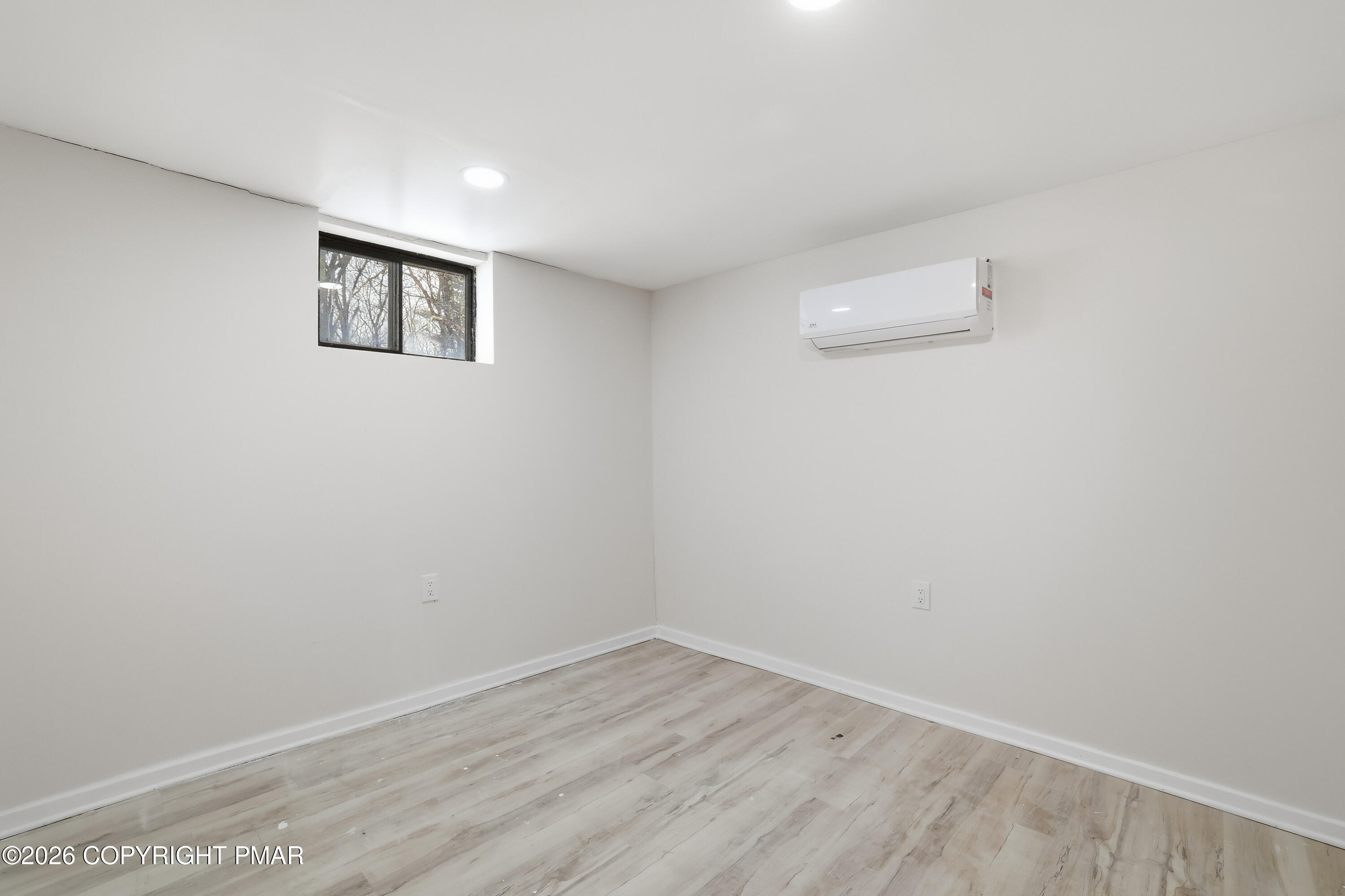 319 Ramble Bush Road Stroudsburg, PA 18360 - Photo 27 of 51 an empty room with a white wall and wooden floor