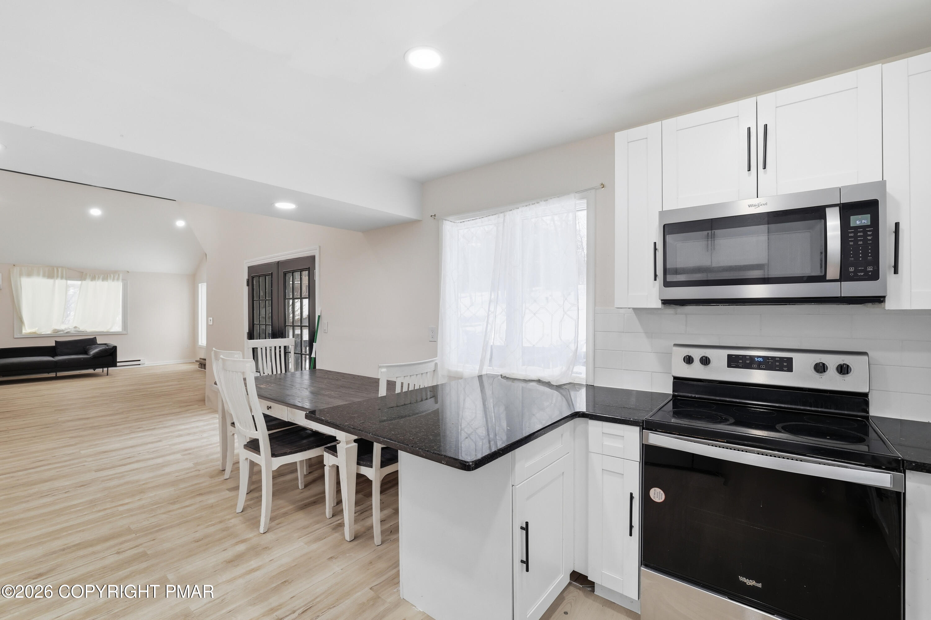 319 Ramble Bush Road Stroudsburg, PA 18360 - Photo 8 of 51 a kitchen with stainless steel appliances a kitchen island hardwood floor sink stove dining table and chairs